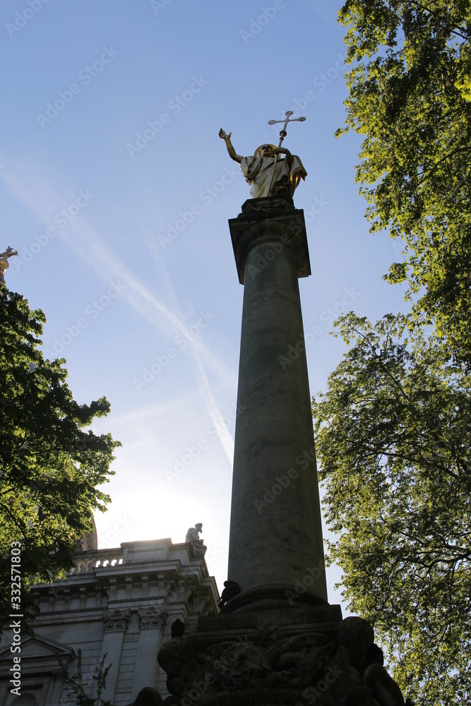 Fototapeta premium Gilt statue of Saint Paul at the top of St Paul's Cross in the cathedral precinct at St Paul's Cathedral, London, UK