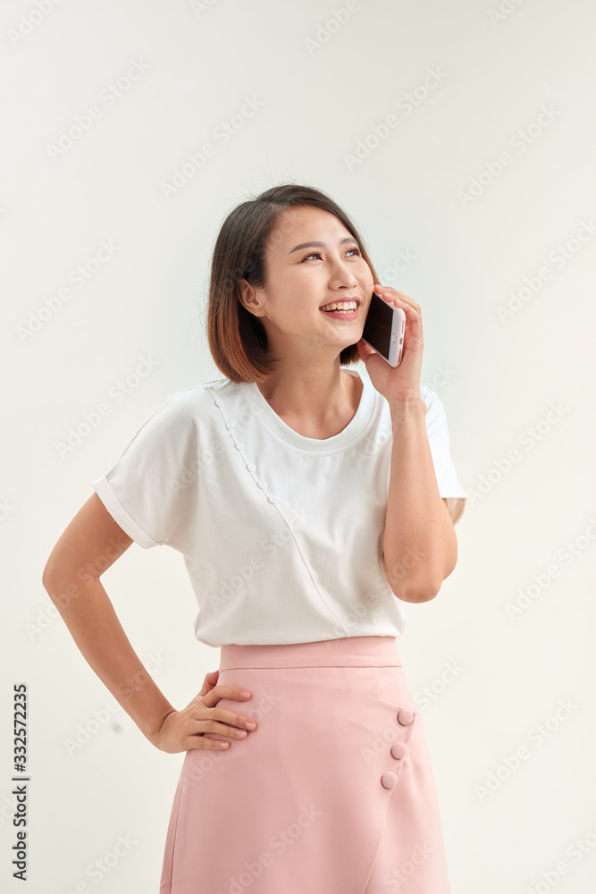 Cheerful young woman talking on mobile phone isolated on white background Cheerful young woman talking on mobile phone isolated on white background
