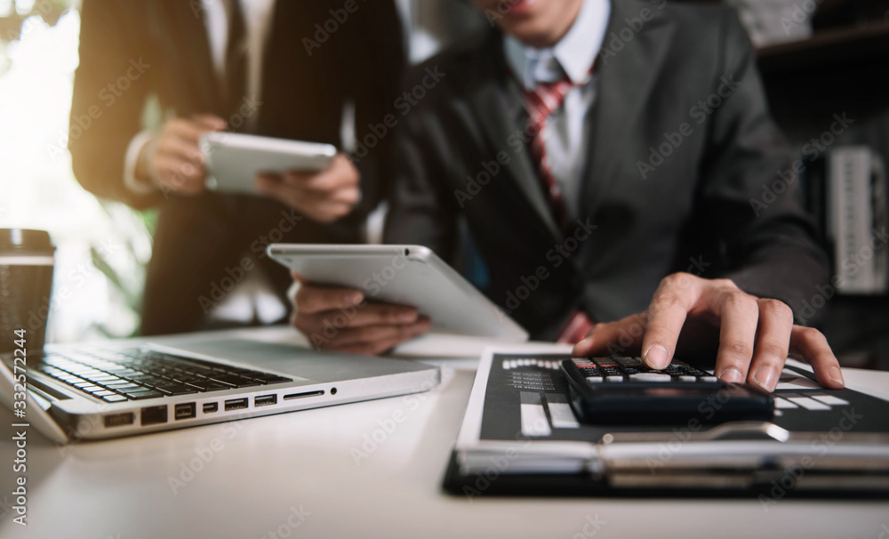 Close up Businessman and partner using calculator and laptop for calculation finance, tax, accounting, statistics and analytic research concept. in the office. Close up Businessman and partner using calculator and laptop for calculation finance, tax, accounting, statistics and analytic research concept. in the office.