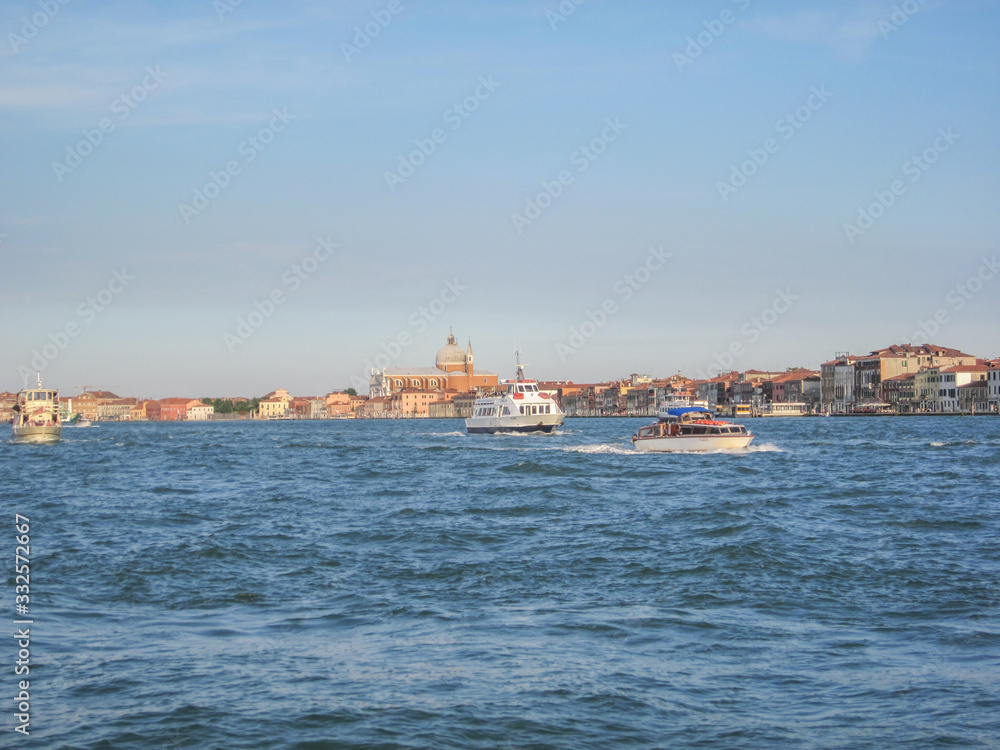 A panoramic shot of exteriors of Piazza San Marco with The Santa Maria della Salute and ships in Grand Canal