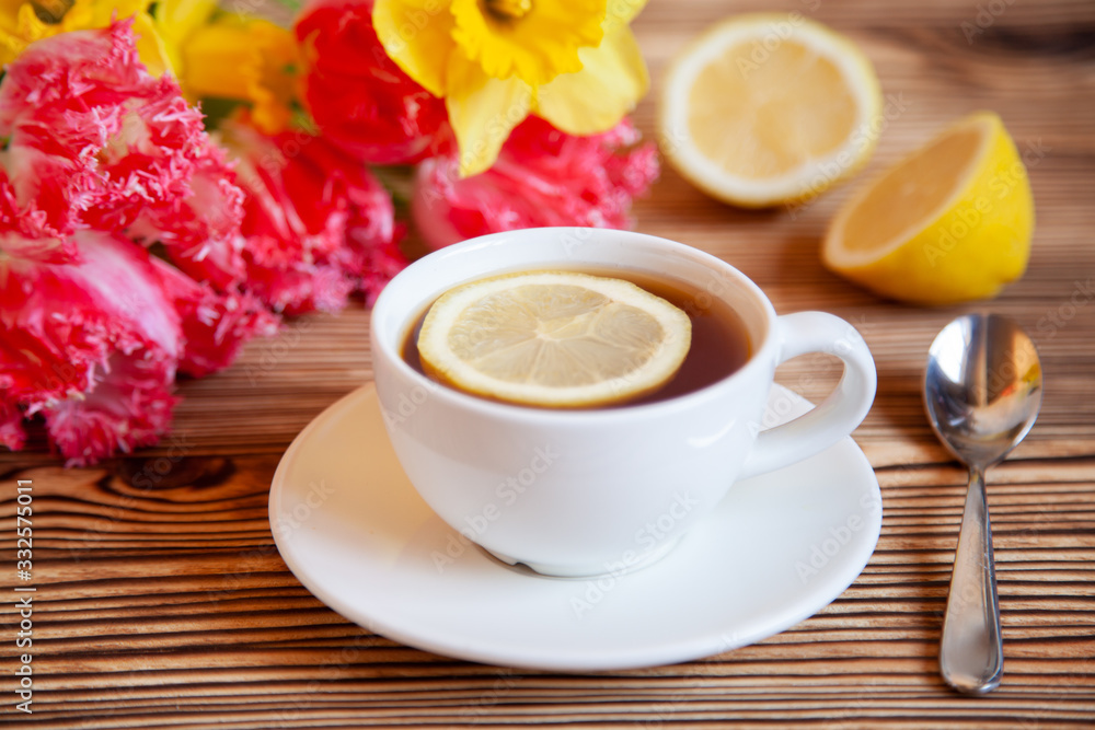 Cap of tea with lemon and flowers on the wooden table. Cap of tea with lemon and flowers on the wooden table.