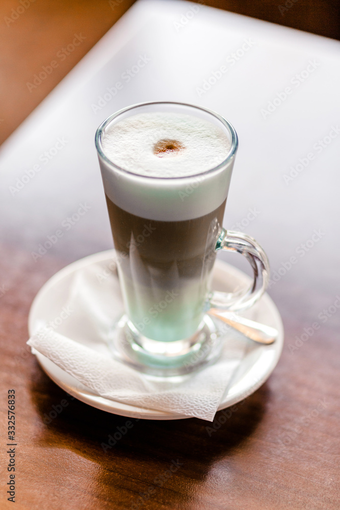 Latte coffee in a large glass stands on a table in a cafe Latte coffee in a large glass stands on a table in a cafe