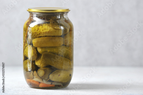 glass jar with an iron lid with canned cucumbers