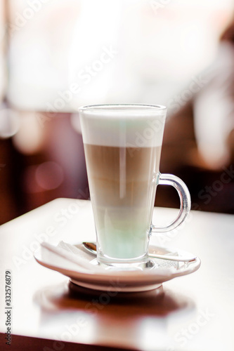 Latte coffee in a large glass stands on a table in a cafe