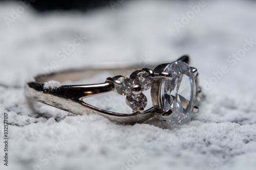 Silver ring with stones on blurred background