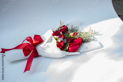 Hand holding a bouquet of beautiful red roses On a white background to congratulate and give as a gift instead of love.concept