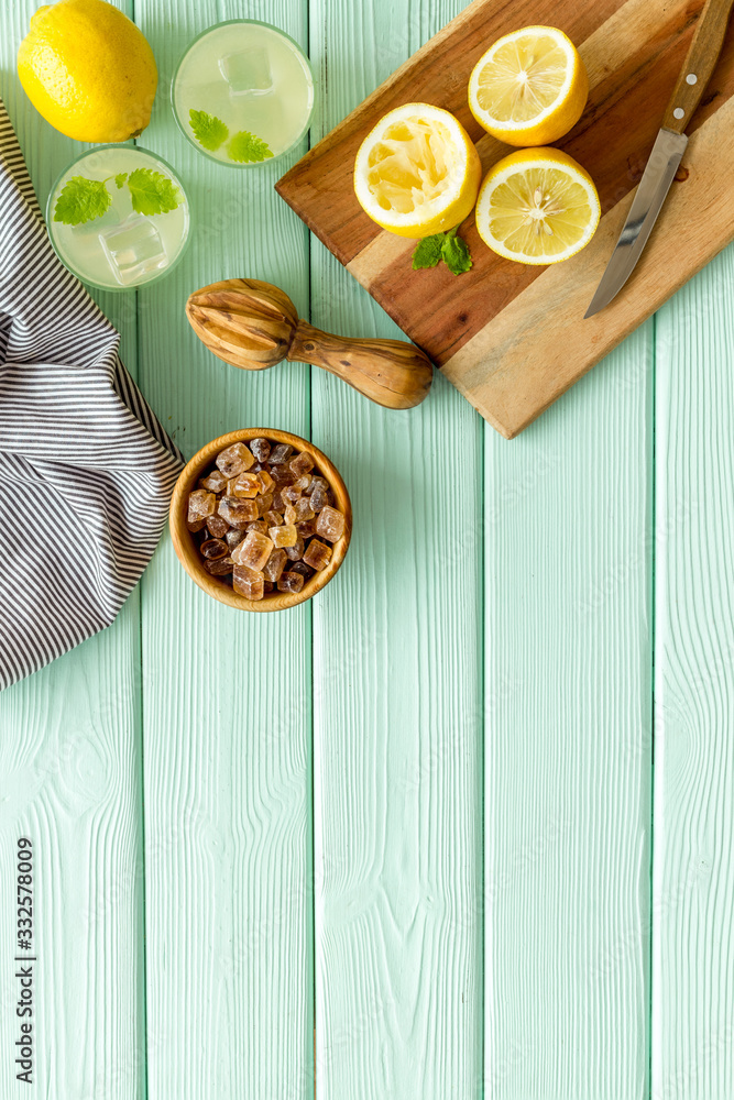 Make lemonade. Drink in bottle near utensil on green wooden background top-down copy space Make lemonade. Drink in bottle near utensil on green wooden background top-down copy space