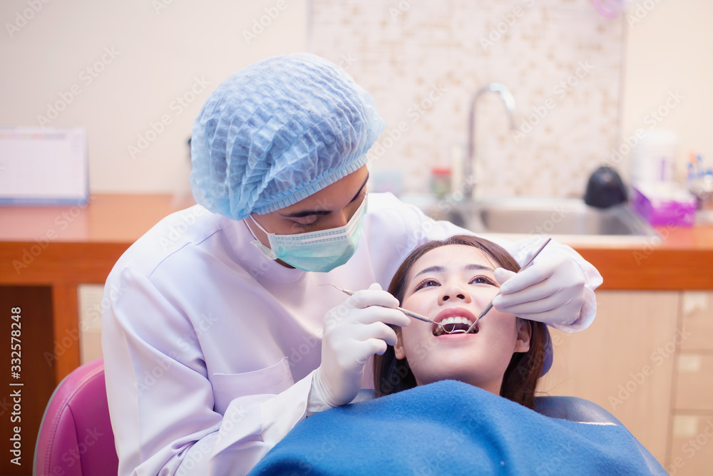 Dentists examining patients lying in chair in a dental clinic. Dentists examining patients lying in chair in a dental clinic.