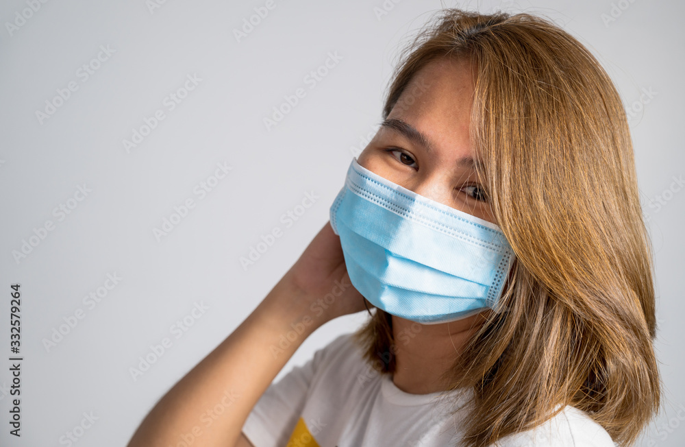 Asian young woman wearing a hygiene protective mask over her face on White background,Coronavirus Covid-19 and Air pollution pm2.5 concept background. Asian young woman wearing a hygiene protective mask over her face on White background,Coronavirus Covid-19 and Air pollution pm2.5 concept background.