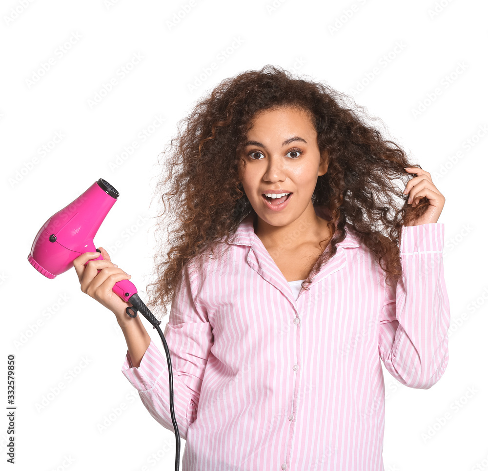 Beautiful young African-American woman with blow dryer on white background Beautiful young African-American woman with blow dryer on white background