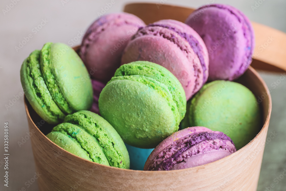 Gift box with tasty macarons on color background, closeup Gift box with tasty macarons on color background, closeup