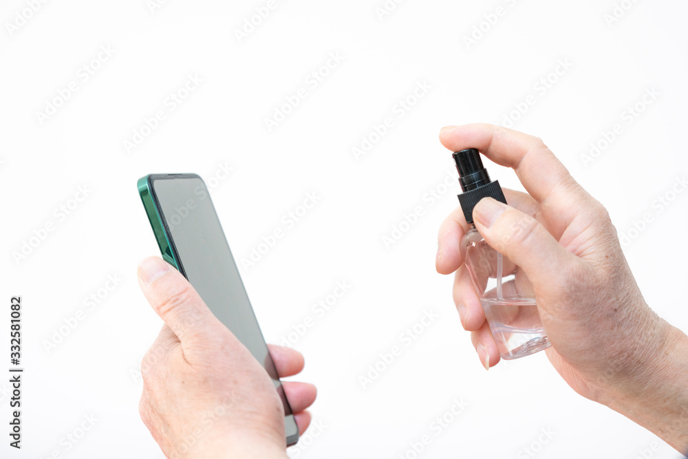 An elderly man is disinfecting a mobile phone An elderly man is disinfecting a mobile phone