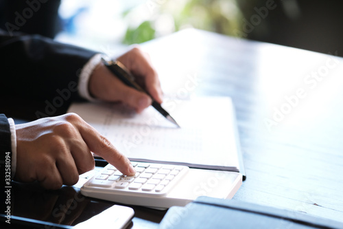 Fotografía Businessman analyzing investment charts and pressing calculator buttons over documents