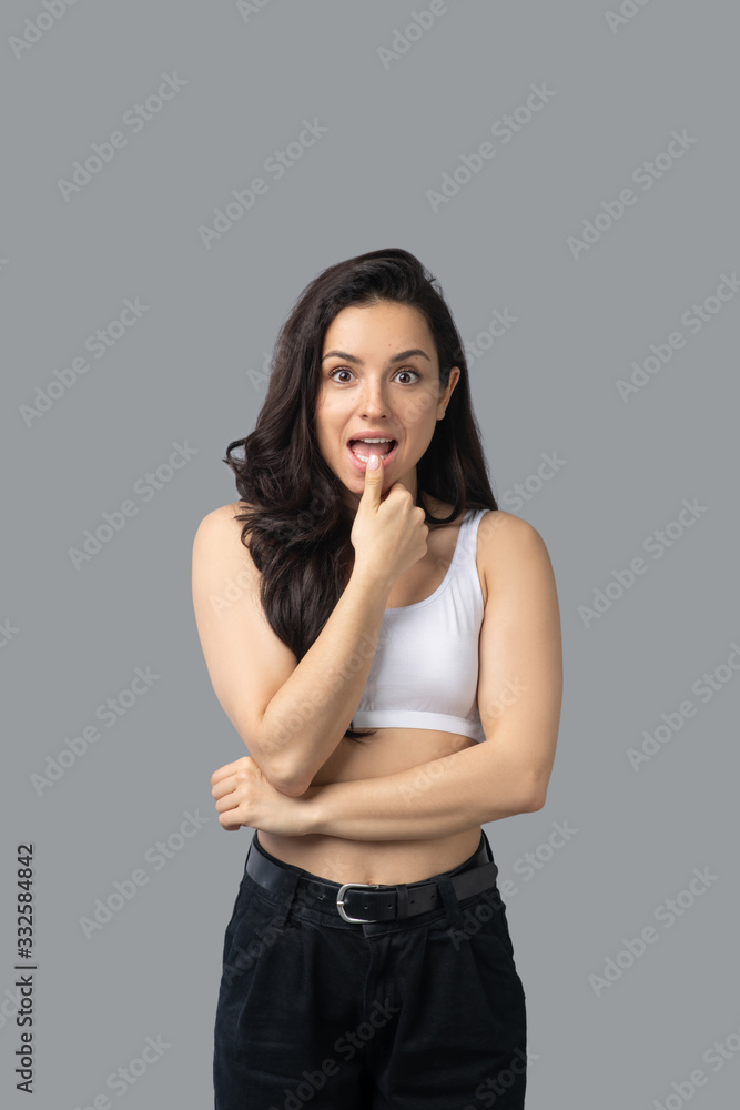 Pretty brunette girl in a white top looking surprised Pretty brunette girl in a white top looking surprised
