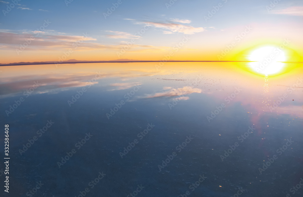 Fototapeta premium Sunrise on Salar de Uyuni in Bolivia covered with water, salt flat desert and sky reflections