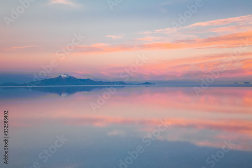 Sunrise on Salar de Uyuni in Bolivia covered with water  salt flat desert and sky reflections