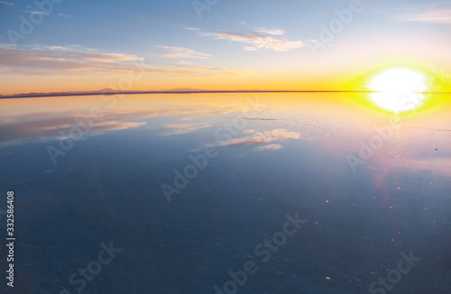 Sunrise on Salar de Uyuni in Bolivia covered with water, salt flat desert and sky reflections © Iuliia Sokolovska