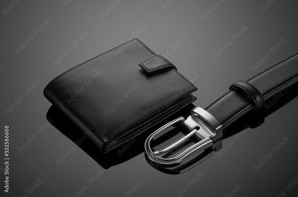 Fashionable leather men's wallet and belt on a black background Fashionable leather men's wallet and belt on a black background