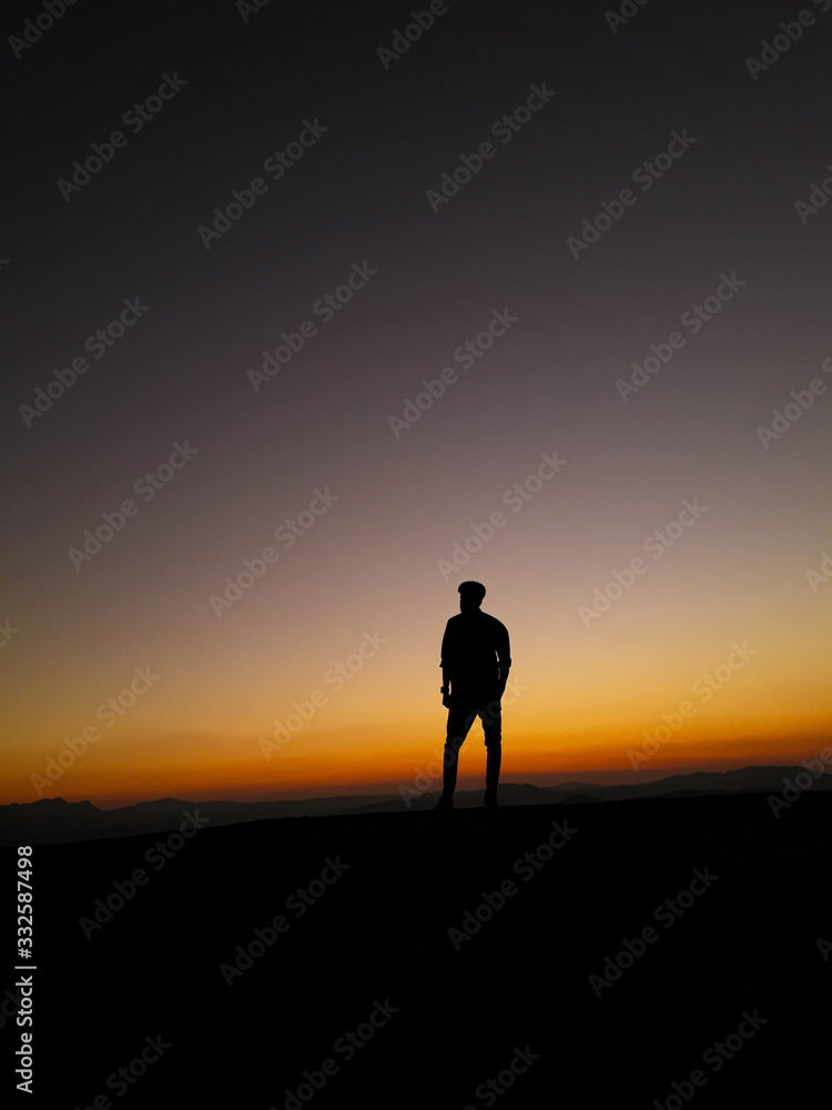 silhouette of man on top of mountain