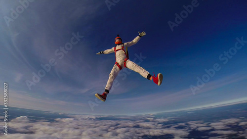 Clean. Clear sky under your feet. A professional skydives. The flow of the wind.