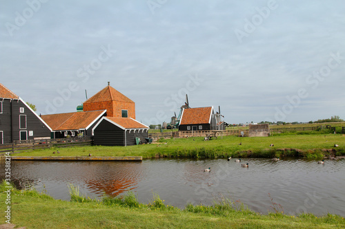 View of traditional Dutch farm houses along a canal in spring at the Zaanse Schans, Zaandam, Netherlands