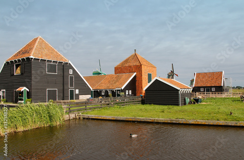 View of traditional Dutch farm houses along a canal in spring at the Zaanse Schans, Zaandam, Netherlands