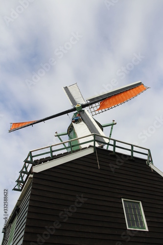 Traditional Dutch windmill with the cloudy sky in spring at the Zaanse Schans, Zaandam, Netherlands