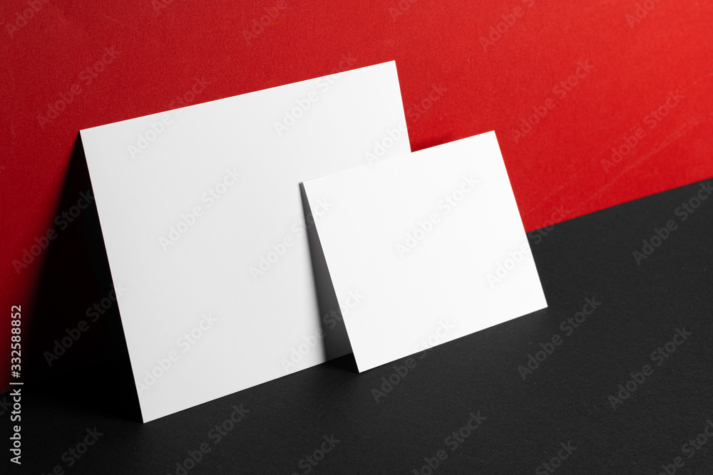 Blank white business cards on red and black paper background, copy space Blank white business cards on red and black paper background, copy space