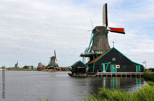 View of traditional Dutch windmills along the canal in spring at the Zaanse Schans  Zaandam  Netherlands