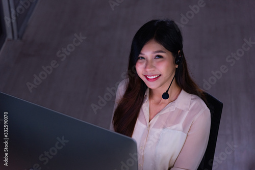 Asian call center business people working late night shift for helping assistance customer in workplace at night time