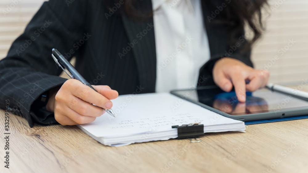 Close up of a young cheerful Asian student female university student studying in self study room in the university library to do her assignment and prepare for examination. Close up of a young cheerful Asian student female university student studying in self study room in the university library to do her assignment and prepare for examination.
