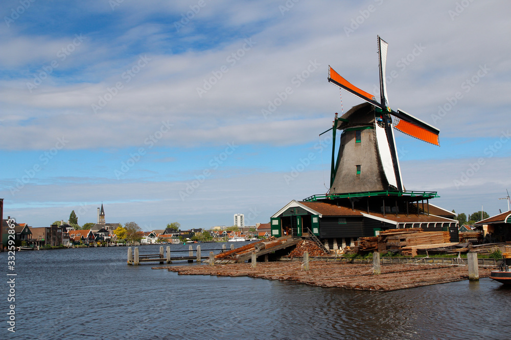 View of traditional Dutch windmills along the canal in spring at the Zaanse Schans, Zaandam, Netherlands