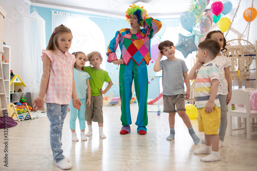 happy kids and clown on birthday party indoors