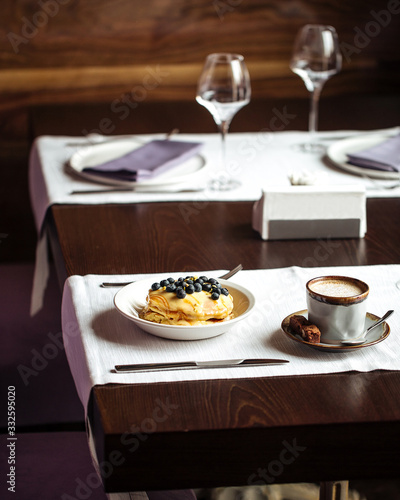 Beautiful breakfast - pancakes with blueberries and coffee on the table