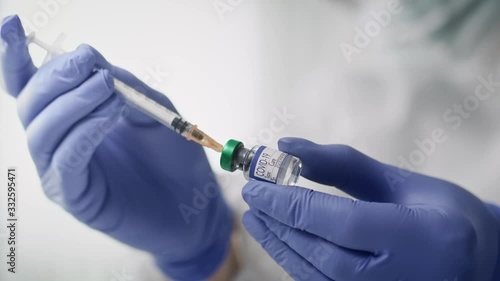 Video of doctor applying coronavirus vaccine into the syringe. Shot with RED helium camera in 8K. photo