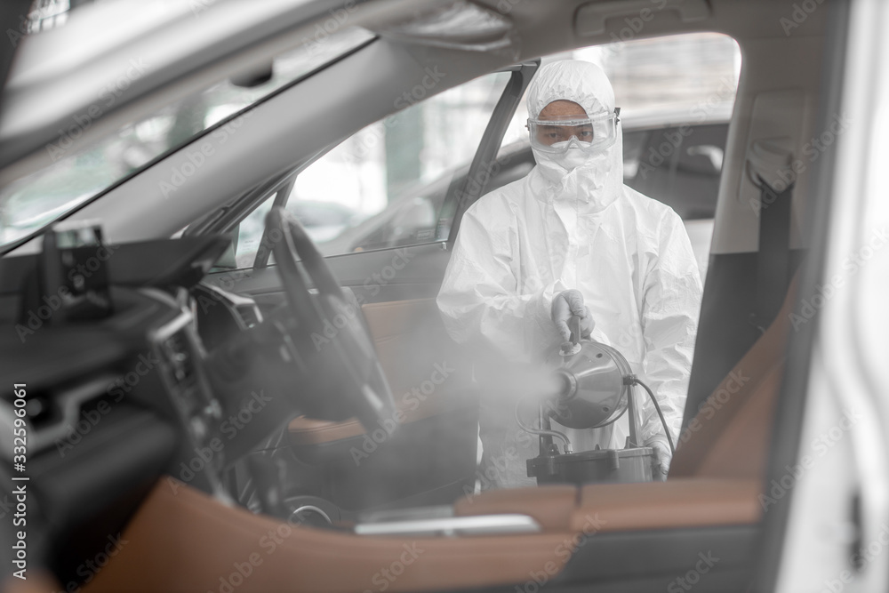 Disinfectant worker character in protective mask and suit sprays bacterial or virus in a car. - obrazy, fototapety, plakaty 