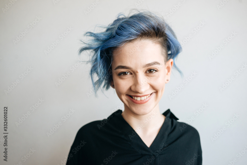 Fototapeta premium A beautiful girl with blue hair is smiling.