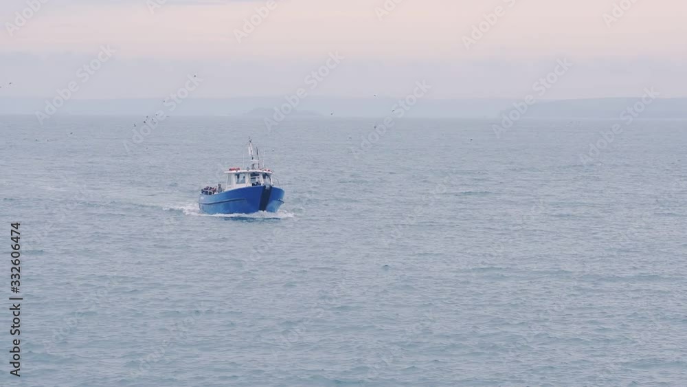 A Boat Sailing Swiftly Across The Big Blue Ocean In Skomer Island, Wales, UK - Wide Shot A Boat Sailing Swiftly Across The Big Blue Ocean In Skomer Island, Wales, UK - Wide Shot