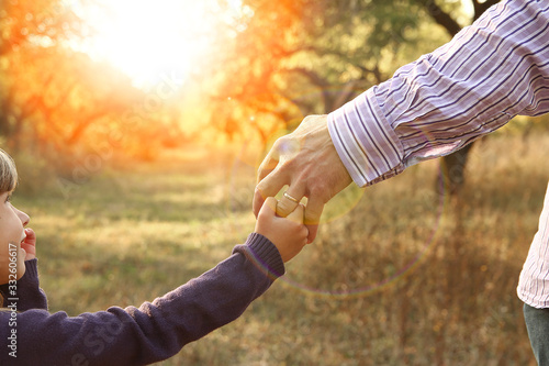 the parent holding the child's hand with a happy background