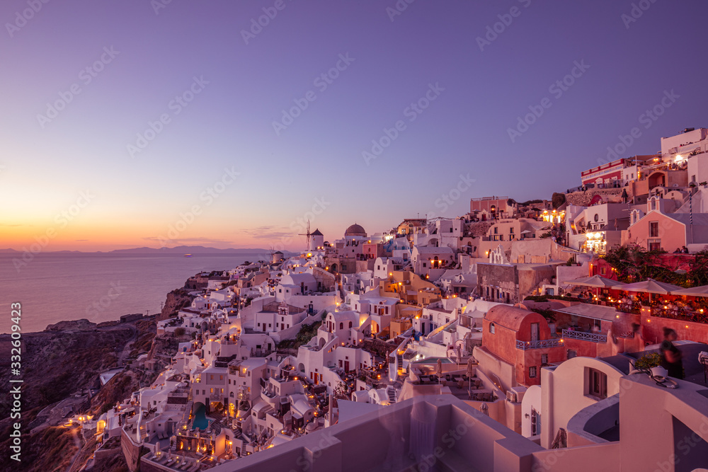 Fototapeta premium Church of Santorini island, Greece. Incredibly romantic sunset on Santorini. Oia village in the morning light. Amazing sunset view with white houses. Island of lovers. Postcard