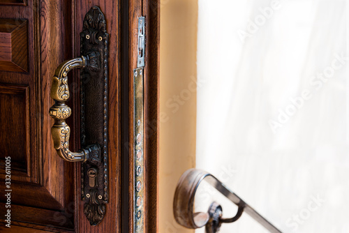 Open wooden door with antique bronze handle, railings and copy space. 