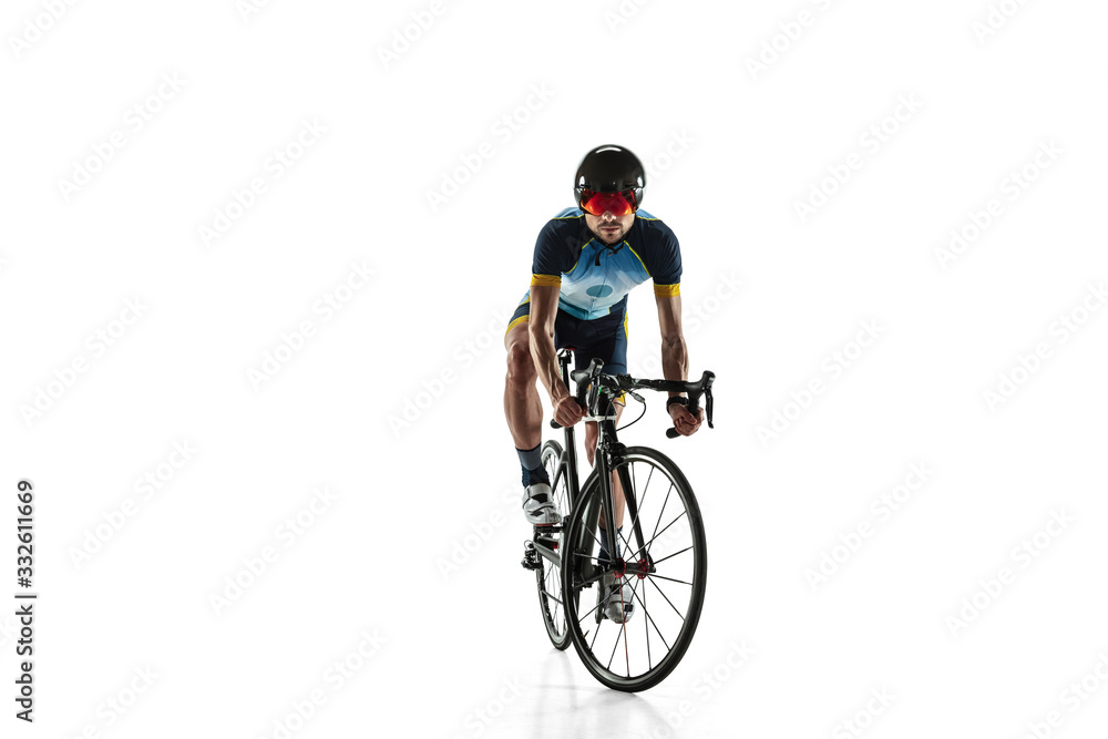 Fototapeta premium Triathlon male athlete cycle training isolated on white studio background. Caucasian fit triathlete practicing in cycling wearing sports equipment. Concept of healthy lifestyle, sport, action, motion.