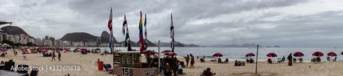 Rio de Janeiro, Brazil - March 1, 2020 - View of Copacabana Beach showing food stand, people, hotels, sand, mountains.