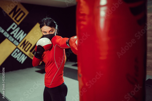 Coronavirus covid-19 prevention, fight. Girl with a medical mask and boxing gloves. Fighting viruses.