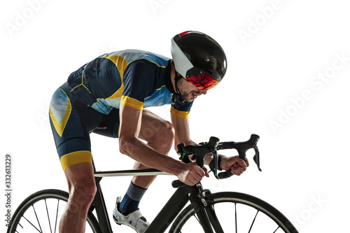 Triathlon male athlete cycle training isolated on white studio background. Caucasian fit triathlete practicing in cycling wearing sports equipment. Concept of healthy lifestyle, sport, action, motion.