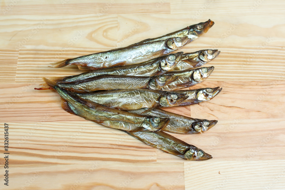 salted, smoked and dried fish, beer snacks, tasty fish on a wooden board salted, smoked and dried fish, beer snacks, tasty fish on a wooden board