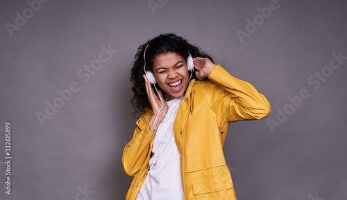 Funny girl dark-skinned listens to music with headphones.