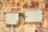 Retro styled junction boxes. Old controlled power system mounted on Natural Stone Wall. Control box. Electric system. Industrial background. Retro electric power boxes. 