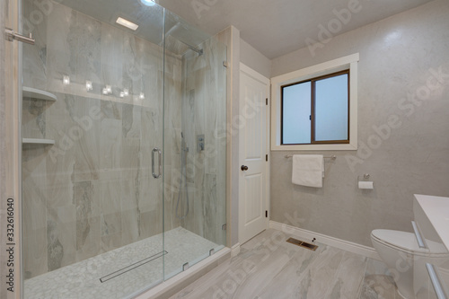 Amamzing modern new bathroom interior with grey venetian plaster, white towels, italian tiles and modern vanity. 