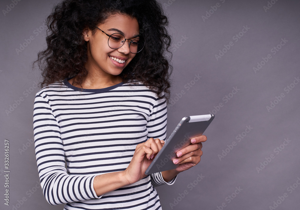 Beautiful young african woman is using a tablet. Beautiful young african woman is using a tablet.